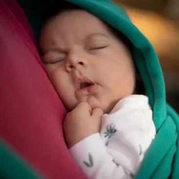 schlafender Säugling im Tragetuch